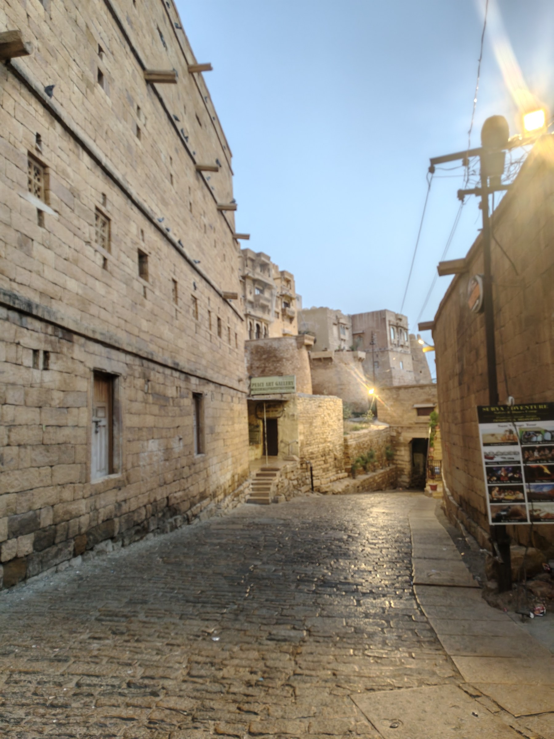 Cobblestone living lane winding through the golden sandstone quarters of Sonar Qila